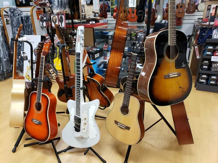 New and used acoustic guitars on stands at Big Island Guitars in Hilo